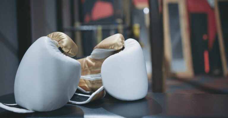 Luvas de boxe brancas novas em cima do ringue, perfeitas para treinos de iniciantes em artes marciais e boxe.