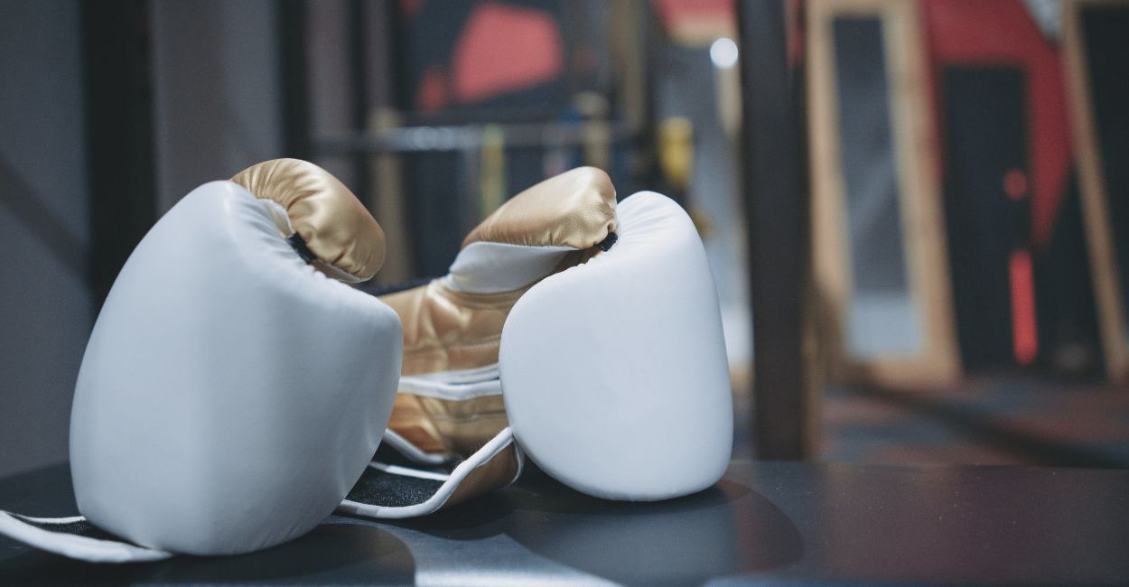Luvas de boxe brancas novas em cima do ringue, perfeitas para treinos de iniciantes em artes marciais e boxe.